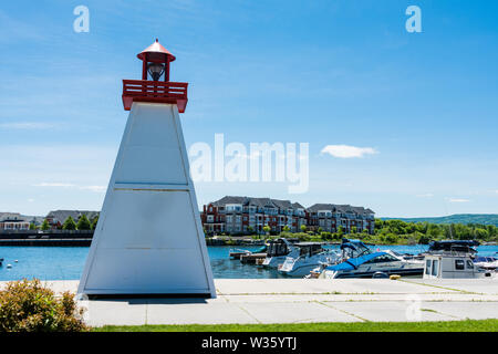 Ein kleiner Leuchtturm am Ufer in der Nähe der Schiffsanlegestelle installiert Stockfoto