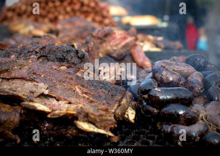 Traditionellen argentinischen "asado" (Grill). Große Stücke Fleisch und Blut Würstchen auf dem Grill. Stockfoto