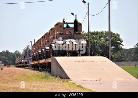 Militärische Fahrzeuge der 1158Th Transportation Company der Wisconsin National Guard sind auf triebwagen Juli 10, 2019, am Fort McCoy, Wis. Die Unternehmen, die Ausrüstung ist in Fort Hood, Texas, geladen, ein Teil einer großen Übung später im Jahr zu sein. Die Schiene wird geladen und die damit verbundenen Arbeiten wurde von der 1158th Soldaten und Mitarbeiter mit der Festung McCoy Logistics Readiness Center Transport Division abgeschlossen. (U.S. Armee Foto von Scott T. Sturkol, Public Affairs Office, Fort McCoy, Wis.) Stockfoto