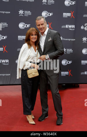 Worms, Deutschland. 12. Juli 2019. Die ehemaligen Boxer und IBF-Weltmeister im Halbschwergewicht Henry Maske (rechts) und seine Frau Manuela (links) für die Kameras am roten Teppich des "nibelungen-festspiele" darstellen. Schauspieler, Politiker und andere VIPs nahmen an der Eröffnung der Nibelungen-festspiele Nibelungen-Festspiele (2019) in Worms. Das Spiel in der 18. Saison des Festivals ist "Uberwaltigung' (Überwinden) zum Thema Thomas Melle, und von Lilja Rupprecht geleitet. Es erzählt von der ursprünglichen Lied der Nibelungen, beginnend am Ende und dem Versuch, die Geschichte neu zu schreiben Stockfoto