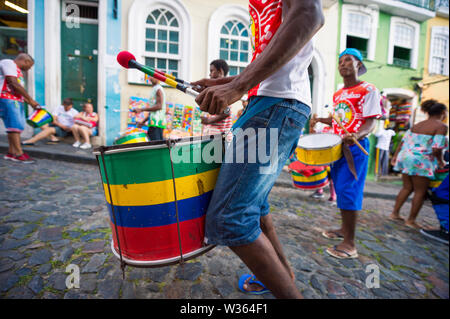 SALVADOR, BRASILIEN - MÄRZ 2018: Eine Gruppe von Trommlern vor bunten kolonialen Architektur von Pelourinho, dem historischen touristischen Bezirk durchführen. Stockfoto