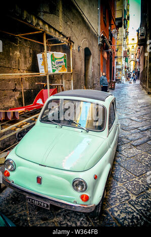 Neapel, Italien - Oktober, 2017: Eine kleine vintage Fiat 500 Auto steht auf einem in der Regel schmale Straße mit Kopfsteinpflaster der mittelalterlichen Altstadt geparkt. Stockfoto