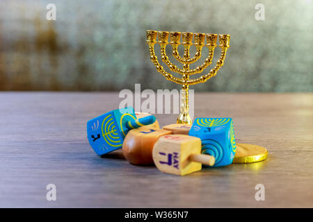 Bild des jüdischen Feiertages Chanukka mit Holz Dreidel Sammlung spinning Top und Schokolade Münzen auf dem Tisch Stockfoto