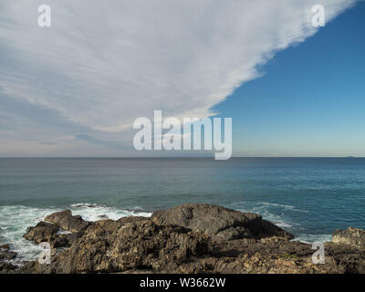 Blautöne in dieser Meereslandschaft mit atemberaubenden Wolkenformationen Den Himmel diagonal teilen, während der Horizont den Himmel teilt Und Meer über dem Meer Stockfoto