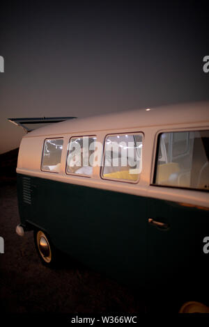 Paar sitzen zusammen in einem Wohnmobil am Strand bei Sonnenuntergang Stockfoto