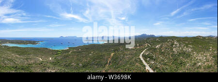 Ansicht von oben, atemberaubenden Panoramablick auf einen schönen grünen Küste vom türkisfarbenen Meer mit einige Boote und Yachten gebadet. Costa Smeralda (Emerald Coas Stockfoto