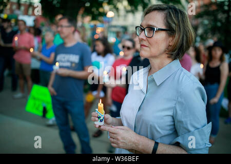 Bloomington, USA. 12. Juli, 2019. Eine Frau hält eine Kerze in die Lichter für die Freiheit: eine Mahnwache zu Ende menschlichen Internierungslagern Kundgebung und Mahnwache auf den Stufen des Monroe County Courthouse in Bloomington. USA Präsident Donald J. sagt Trumpf EIS wird Razzien gegen Immigranten ohne Papiere in amerikanischen Städten über das Wochenende durchführen. Credit: SOPA Images Limited/Alamy leben Nachrichten Stockfoto