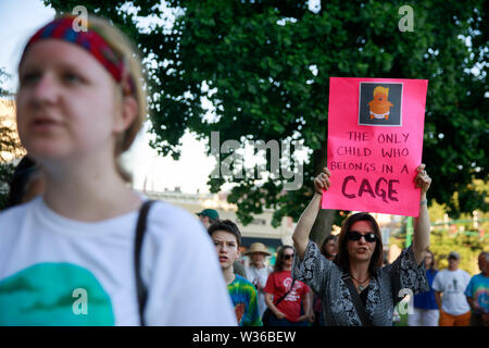 Bloomington, USA. 12. Juli, 2019. Eine Frau hält ein Schild mit einem Foto von Baby Trump, "Lesen", das einzige Kind, das gehört in ein Käfig", als die Demonstranten für die Lichter für die Freiheit: eine Mahnwache zu Ende menschlichen Internierungslagern Kundgebung und Mahnwache auf den Stufen des Monroe County Courthouse in Bloomington sammeln. USA Präsident Donald J. sagt Trumpf EIS wird Razzien gegen Immigranten ohne Papiere in amerikanischen Städten über das Wochenende durchführen. Credit: SOPA Images Limited/Alamy leben Nachrichten Stockfoto