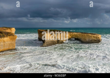 Schöne Sicht auf die London Arch (ehemals London Bridge) entlang der Great Ocean Road gegen einen stürmischen Himmel, Australien Stockfoto