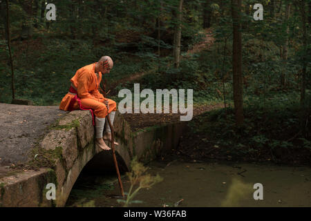 Schlacht Mönch in orange Kleidung im Sommer Wald Stockfoto