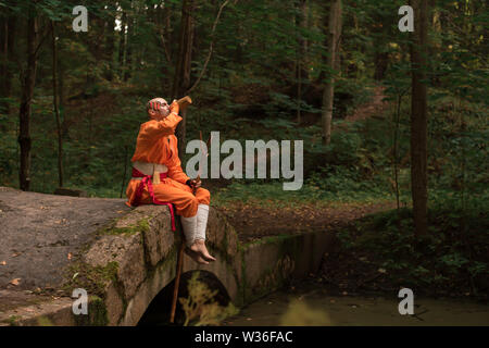 Schlacht Mönch in orange Kleidung im Sommer Wald Stockfoto