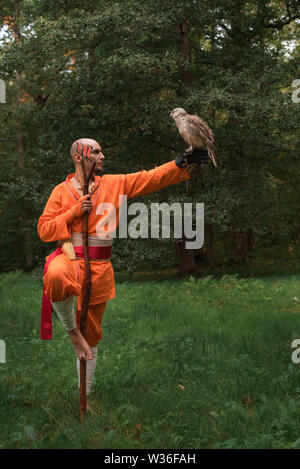 Buddhistischer Mönch mit einem Vogel auf seiner Hand im Wald im Sommer Stockfoto