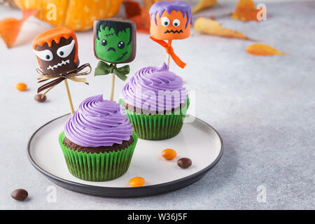 Halloween Muffins und Kuchen Pops oder in Schokolade getauchte Marshmallow Monster mit lustigen Gesichtern. Selektiver Fokus, kopieren. Stockfoto