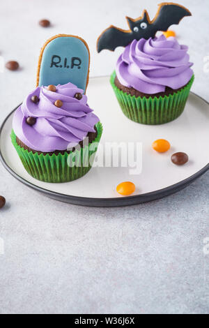 Halloween Cupcakes mit Lebkuchen Cookies: Grabstein und bat. Festliche Leckereien Idee mit Kopie Raum, selektive konzentrieren. Stockfoto