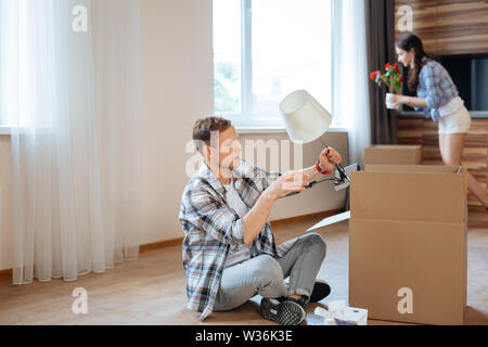 Mann die Lampe aus der Box während der Bewegung Stockfoto