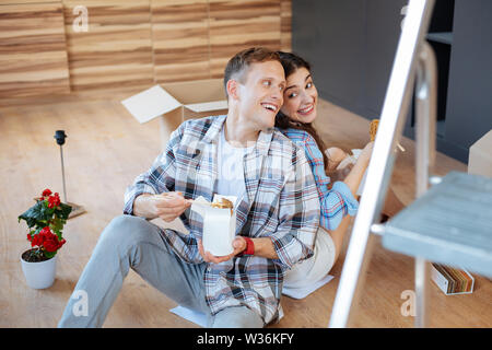 Der Mann und die Frau das Essen lecker Nudeln auf dem Boden sitzend Stockfoto