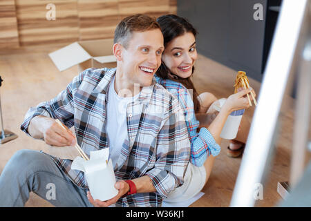 Paar Essen Nudeln nach dem Auspacken Boxen mit Dinge Stockfoto