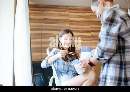 Freundliche paar Nudeln Essen zum Mitnehmen in Bewegung auf neue Wohnung Stockfoto