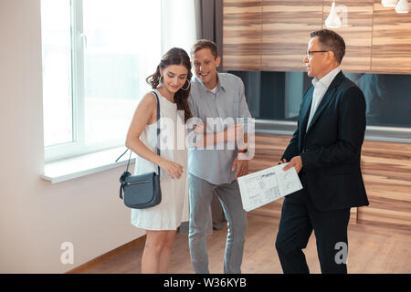 Ein paar der jungen Unternehmer in der Nähe von Realtor stehend Stockfoto