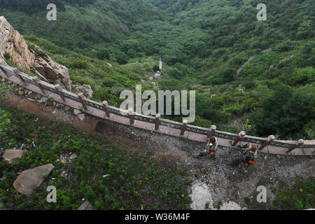 (190713) - ZHANGZI, Juli 13, 2019 (Xinhua) - Förster Herr er Xiaohong (L) und Lin Zhongkui Patrouille auf dem Berg Fajiu, 25 km westlich von zhangzi County, im Norden der chinesischen Provinz Shanxi, 12. Juli 2019. Es ist ein Wald-patroller Station auf dem Berg Fajiu wo der Wald Abdeckung steht fast 90 Prozent. Herr er Xiaohong wurde in den Schutz der Wälder seit 34 Jahren, seit er 19 war. Zusammen mit seinem Kollegen, Herrn muss er Patrouille zweimal vom frühen Morgen bis zum Abend für das ganze Jahr, um sicherzustellen, dass die Wälder sind in der guten Situation. Unter ihrem Schutz, gibt es keine wilden worden w Stockfoto