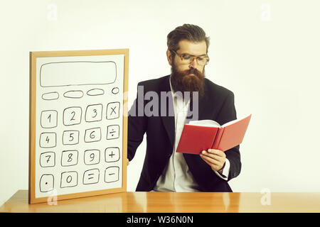 Die Jungen gut aussehenden bärtigen Mann Wissenschaftler oder Professor in Lehrer Gläser mit langen Bart Holding mit Taschenrechner und roten Buch oder Briefpapier sitzen Stockfoto