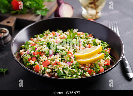 Tabbouleh Salat. Traditionelle orientalische oder arabische Gericht. Levantinischen vegetarischen Salat mit Petersilie, Minze, Bulgur, Tomate. Stockfoto