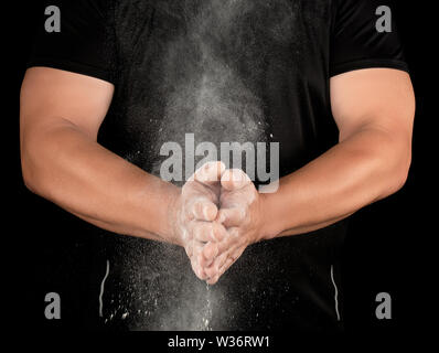 Athlet in schwarze Kleidung, Klatschen, weiß Talkum Magnesium weg fliegen, Vorbereitung für sportliche Ereignisse Stockfoto