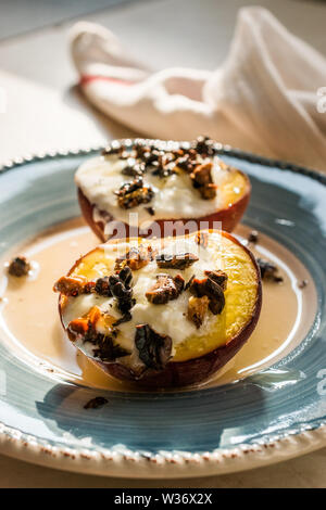 Gebackene Pfirsiche mit griechischem Joghurt, gerösteten Nüssen und Honig/Nektarinen. Organische Dessert. Stockfoto