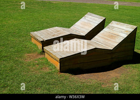 Paar Holzbänken auf der Wiese in der Sonne in den öffentlichen Park Stockfoto