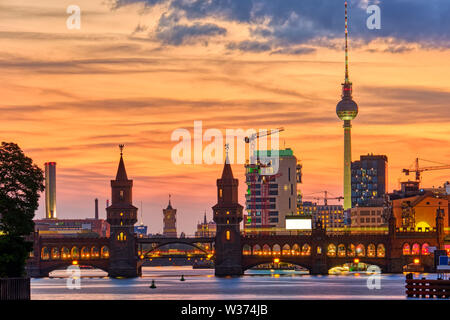 Dramatischer Sonnenuntergang an der Oberbaumbrücke in Berlin mit dem berühmten Fernsehturm auf der Rückseite Stockfoto