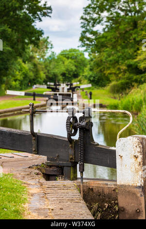 Detail einer Sperre Klappenmechanismus mit einem Flug der Sperren im Hintergrund auf dem Tardebigge Schlösser, Worcester und Birmingham Canal, Worcestershire Stockfoto