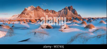 Zauberhafte Vestrahorn Berge und Strand in Island bei Sonnenaufgang. Panoramablick auf eine atemberaubende isländische Landschaft. Vestrahorn Berg auf dem Stokksnes Stockfoto