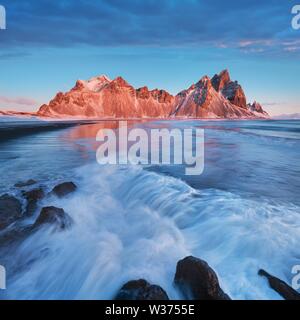 Zauberhafte Vestrahorn Berge und Strand in Island bei Sonnenaufgang. Panoramablick auf eine atemberaubende isländische Landschaft. Vestrahorn Berg auf dem Stokksnes Stockfoto