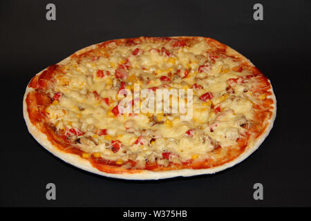 Scheiben frische leckere Pizza mit köstlichen Zutaten auf bunte Platte auf schwarzen Hintergrund. Leckere Pizza auf dem Teller auf schwarzem Hintergrund isoliert. Stockfoto