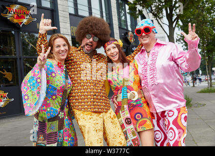 Hamburg, Deutschland. 13. Juli, 2019. Besucher in bunten Kostümen stellen am Millerntorplatz vor Beginn des Schlagermoves. Quelle: Georg Wendt/dpa/Alamy leben Nachrichten Stockfoto