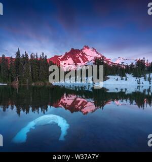 Mit einer Höhe von 10,492 Metern ist Mt Jefferson der zweithöchste Berg von Oregon. Spiegelt sich hier in Scout Lake bei Sonnenuntergang. Der Schnee bedeckte die zentrale Oregon Cascade Stockfoto