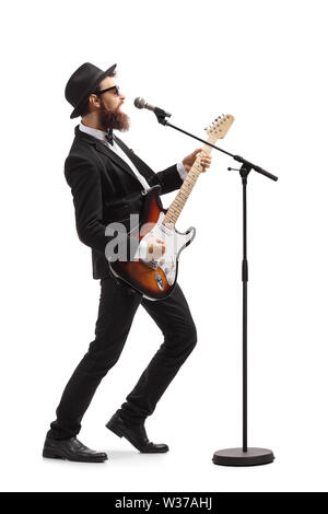 Volle Länge Profil Schuß eines männlichen Künstler spielen eine Bass Gitarre und Gesang auf einem Mic auf weißem Hintergrund Stockfoto