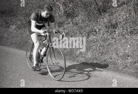 1950er Jahre, historisch, ein junger Amateur männlicher Radfahrer auf seinem Rennrad draußen auf der Straße, sein Ersatz-Fahrradschlauch umwickelt ihn, England, Großbritannien. Stockfoto