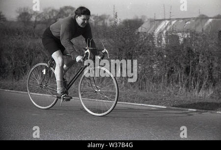 1950er Jahre, historisch, ein portabler Amateur-männlicher Radfahrer, der die Kleidung der Epoche trägt, langärmliges Trikot und Shorts, fährt auf einem Drop-Hold-Fahrrad auf der Straße, England, Großbritannien. Stockfoto