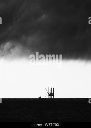 Gulf Shores, AL USA - 05/09/2019 - Öl Plattform mit Gewitterwolken 1 B&W Stockfoto