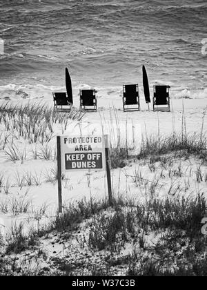 Gulf Shores, AL USA - 05/09/2019 - Geschützter Bereich und Liegen in B&W Stockfoto