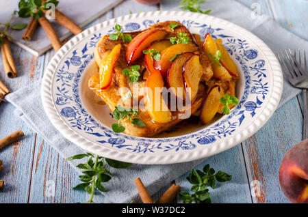Köstliche Dessert mit frischen Pfirsichen, gebraten mit Ahornsirup und French Toast Stockfoto
