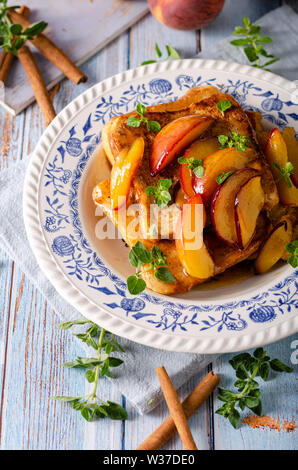 Köstliche Dessert mit frischen Pfirsichen, gebraten mit Ahornsirup und French Toast Stockfoto