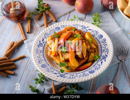 Köstliche Dessert mit frischen Pfirsichen, gebraten mit Ahornsirup und French Toast Stockfoto