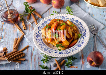 Köstliche Dessert mit frischen Pfirsichen, gebraten mit Ahornsirup und French Toast Stockfoto