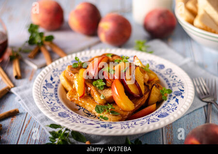 Köstliche Dessert mit frischen Pfirsichen, gebraten mit Ahornsirup und French Toast Stockfoto