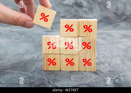 Hand Holz cube Block immer auf die Oberseite mit Symbol Prozentsatz Symbol oben. Zinssatz Finanz- und Hypothekenzinsen Konzept Stockfoto