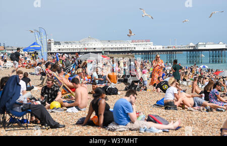 Brighton UK 13. Juli 2019 - Brighton Beach besetzt ist, wie die Besucher der heißen Sonne mit Temperaturen wieder Erreichen der Mitte der 20er Jahre in den Süden Osten genießen. Foto: Simon Dack/Alamy leben Nachrichten Stockfoto