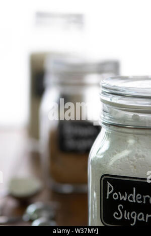 Puderzucker in eine jar mit anderen Backzutaten auf unscharf Hintergrund Stockfoto