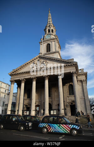 London Taxis, schwarze Taxis fahren St. Martin-in-the-Fields, eine der berühmtesten Kirchen in London Stockfoto